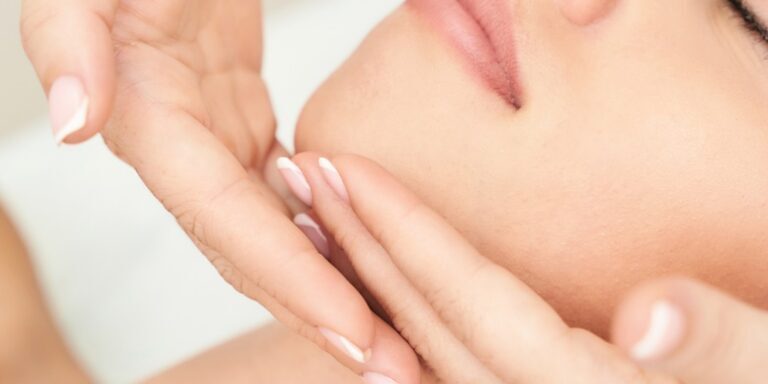 Fabulously Beautiful Kent, Amy Burbridge Home Salon. Female client receiving a facial massage. Therapist hands cup client chin on